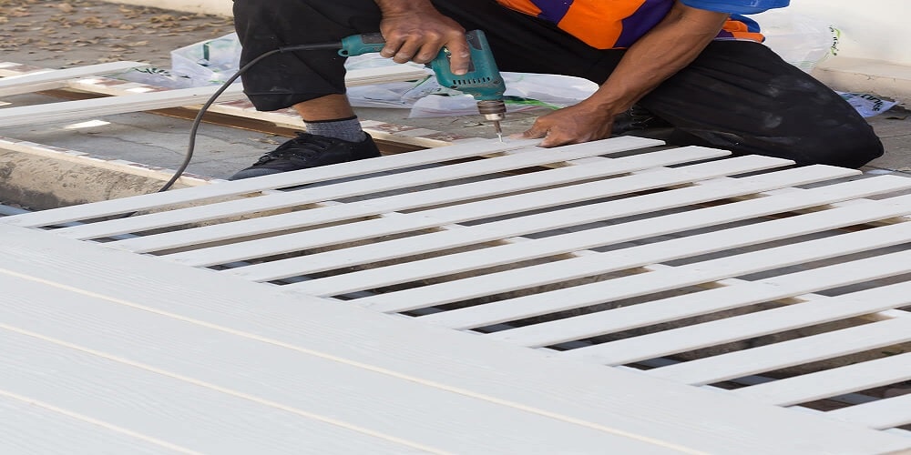 Carpenter hands using electric drill on wood - Golden Gate Fences